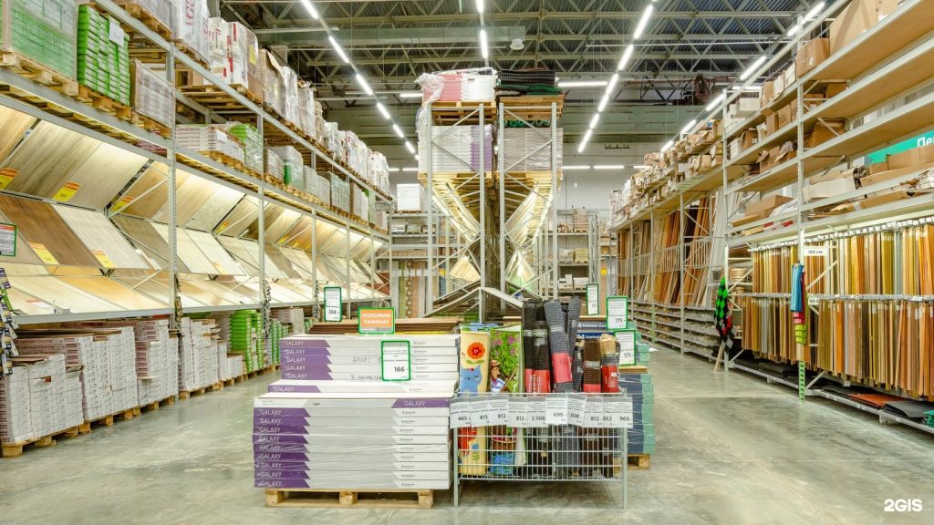 Estoque de Materiais de Construção: prateleiras altas com pisos e madeira.