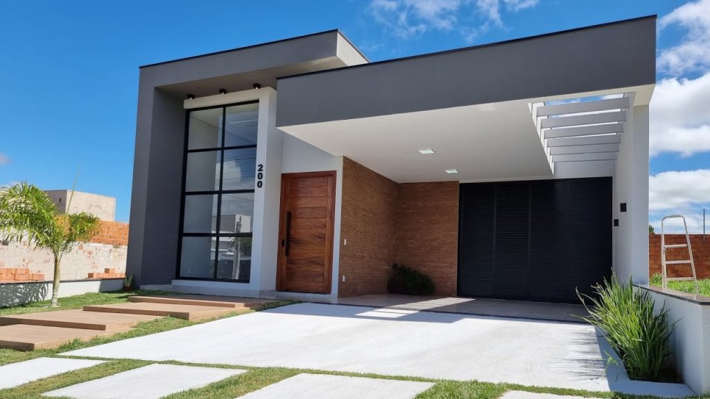 Pequena Mansão com fachada moderna, porta de madeira e garagem discreta.