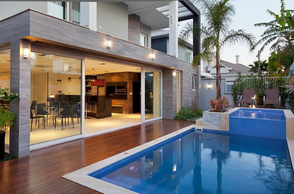 Piscina, deck de madeira, área gourmet: lazer de uma Mansão moderna.