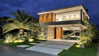 Fachada noturna de Construção de Alto Padrão com jardim iluminado.