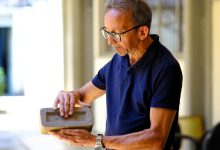 Pesquisador segurando tijolo sustentável feito com bagaço da cana-de-açúcar.