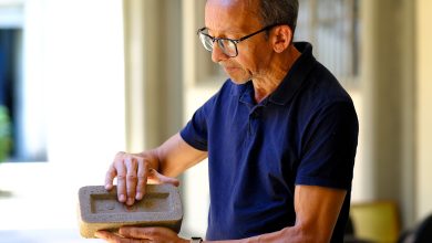 Pesquisador segurando tijolo sustentável feito com bagaço da cana-de-açúcar.