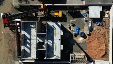 Vista aérea de obra modular, guindaste e fundação de Construção Pré-Fabricada.