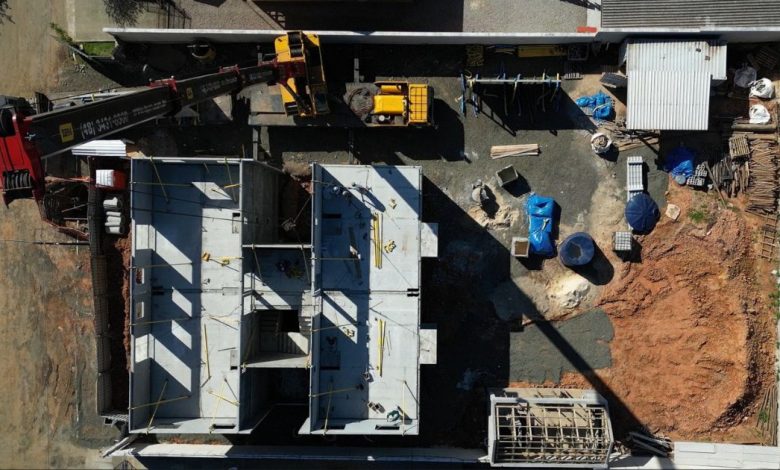 Vista aérea de obra modular, guindaste e fundação de Construção Pré-Fabricada.