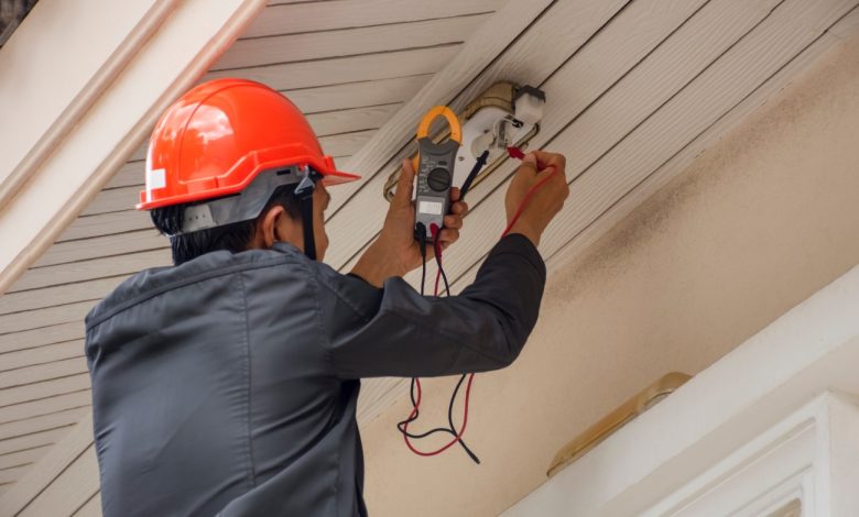 Eletricista 24 Horas medindo tensão externa com alicate amperímetro.