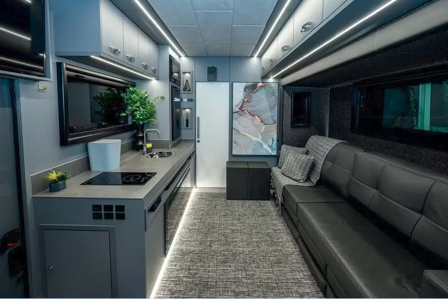Cozinha gourmet e lounge com sofá de couro, interior do Motorhome de R$ 3,3 Milhões.